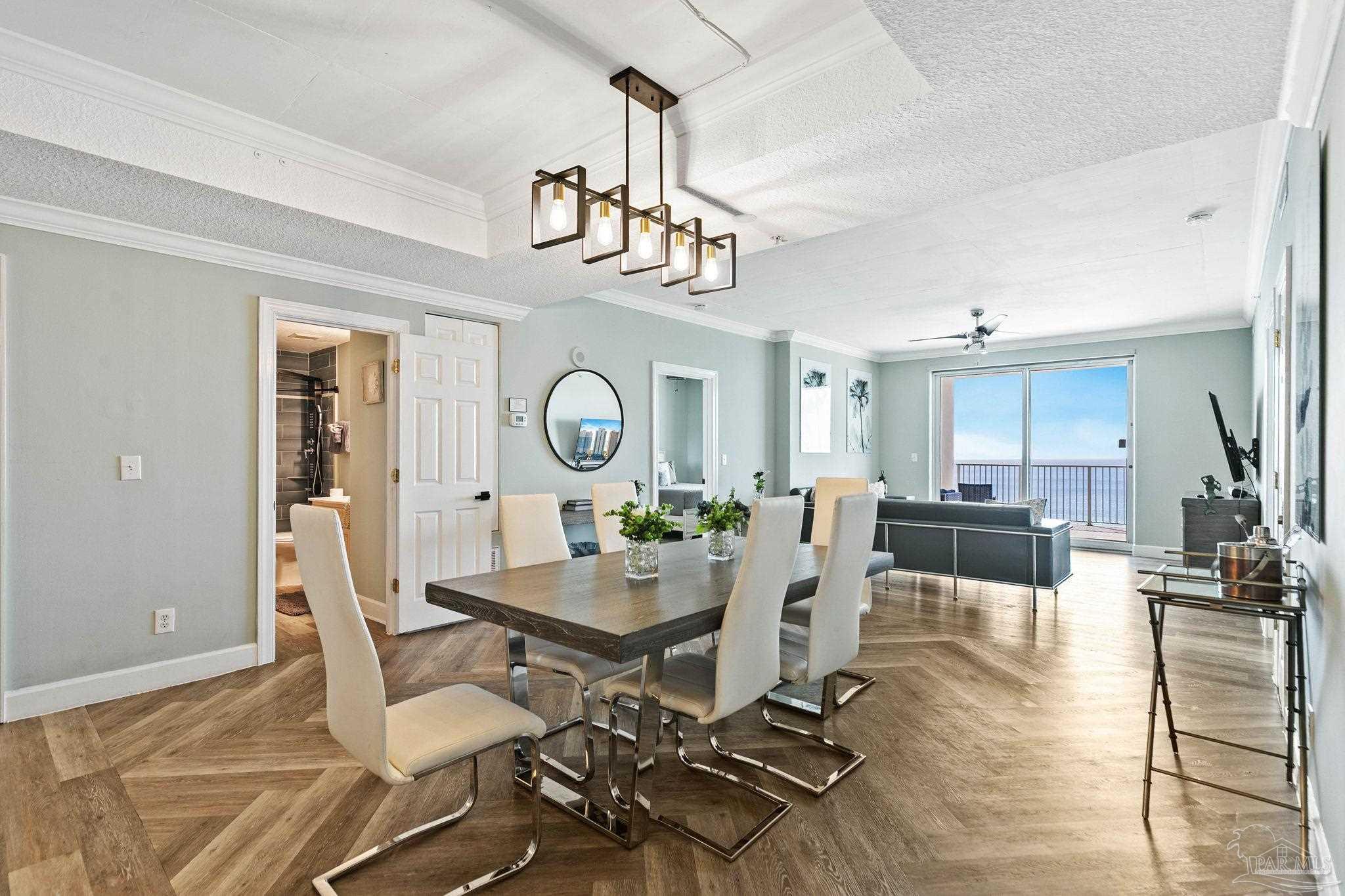 10611 Front Beach Road, Unit 1303 Panama City Beach, FL 32408 - Photo 12 of 71 a view of a dining room with furniture a rug and wooden floor