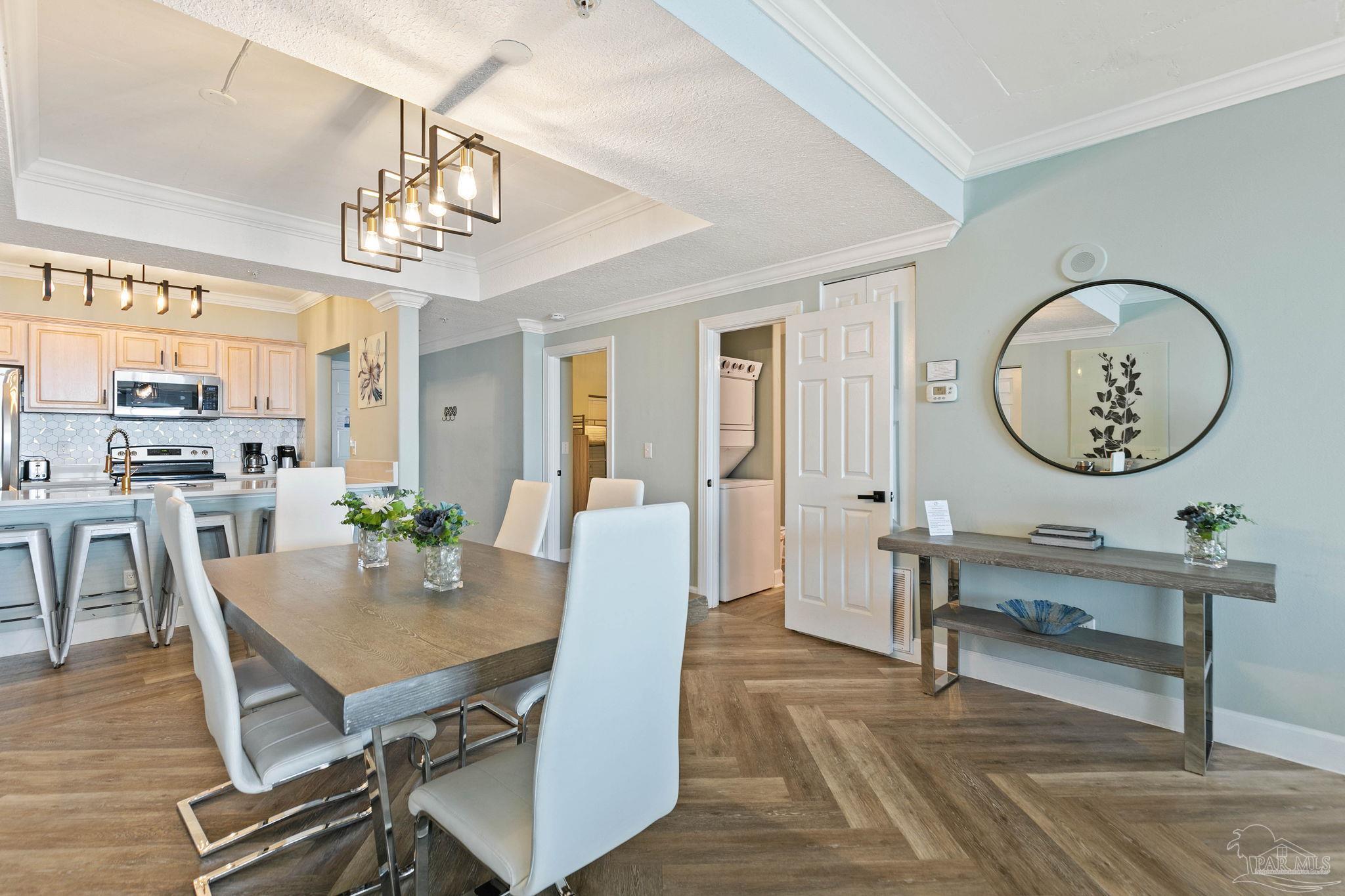 10611 Front Beach Road, Unit 1303 Panama City Beach, FL 32408 - Photo 20 of 71 a view of a dining room with furniture a chandelier and wooden floor