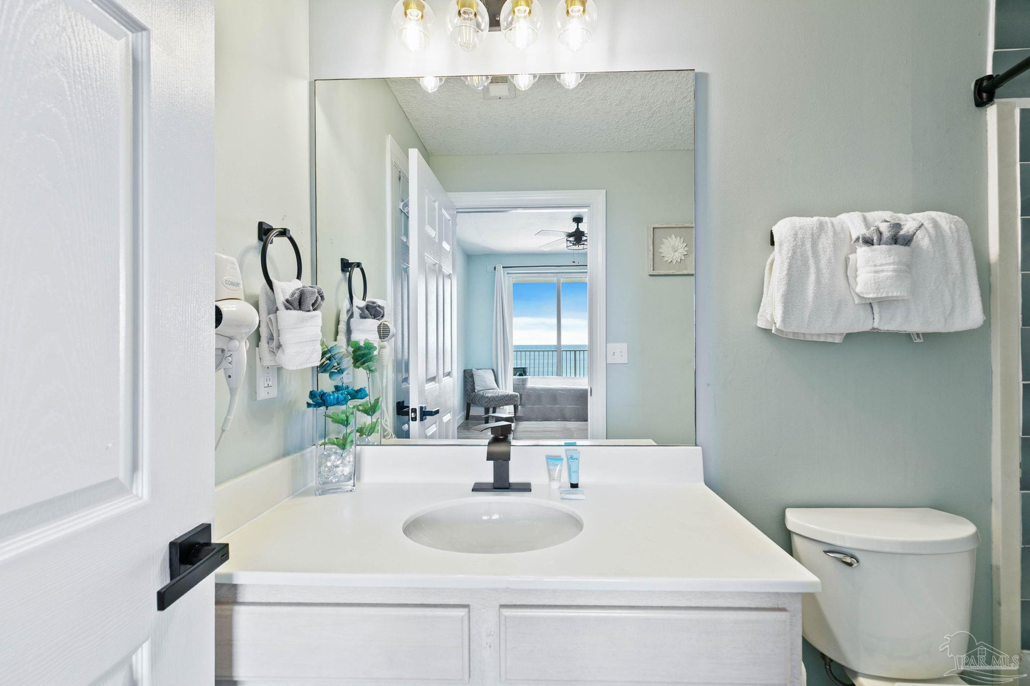 10611 Front Beach Road, Unit 1303 Panama City Beach, FL 32408 - Photo 33 of 71 a bathroom with a toilet sink and mirror