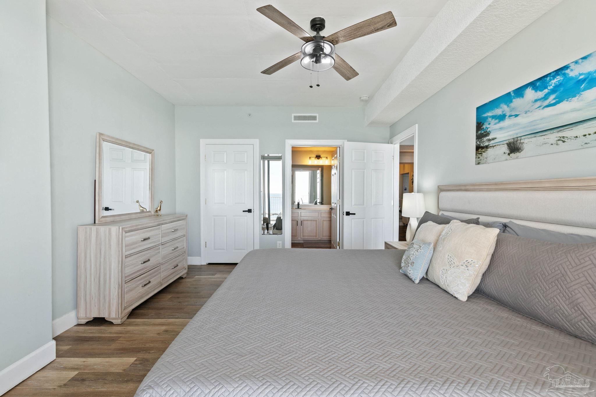 10611 Front Beach Road, Unit 1303 Panama City Beach, FL 32408 - Photo 36 of 71 a spacious bedroom with a bed and a chandelier