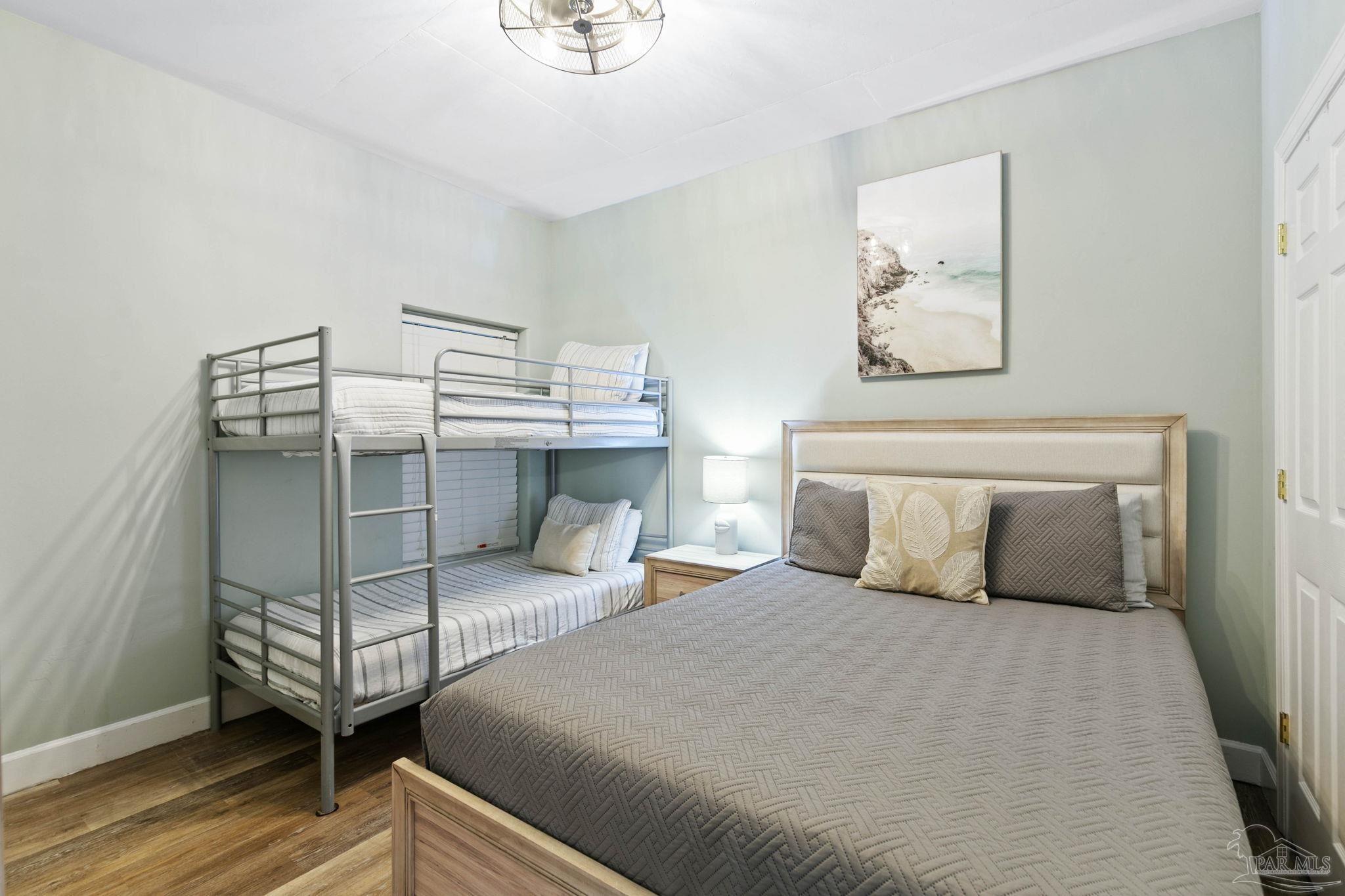 10611 Front Beach Road, Unit 1303 Panama City Beach, FL 32408 - Photo 40 of 71 a bedroom with a bed and wooden floor