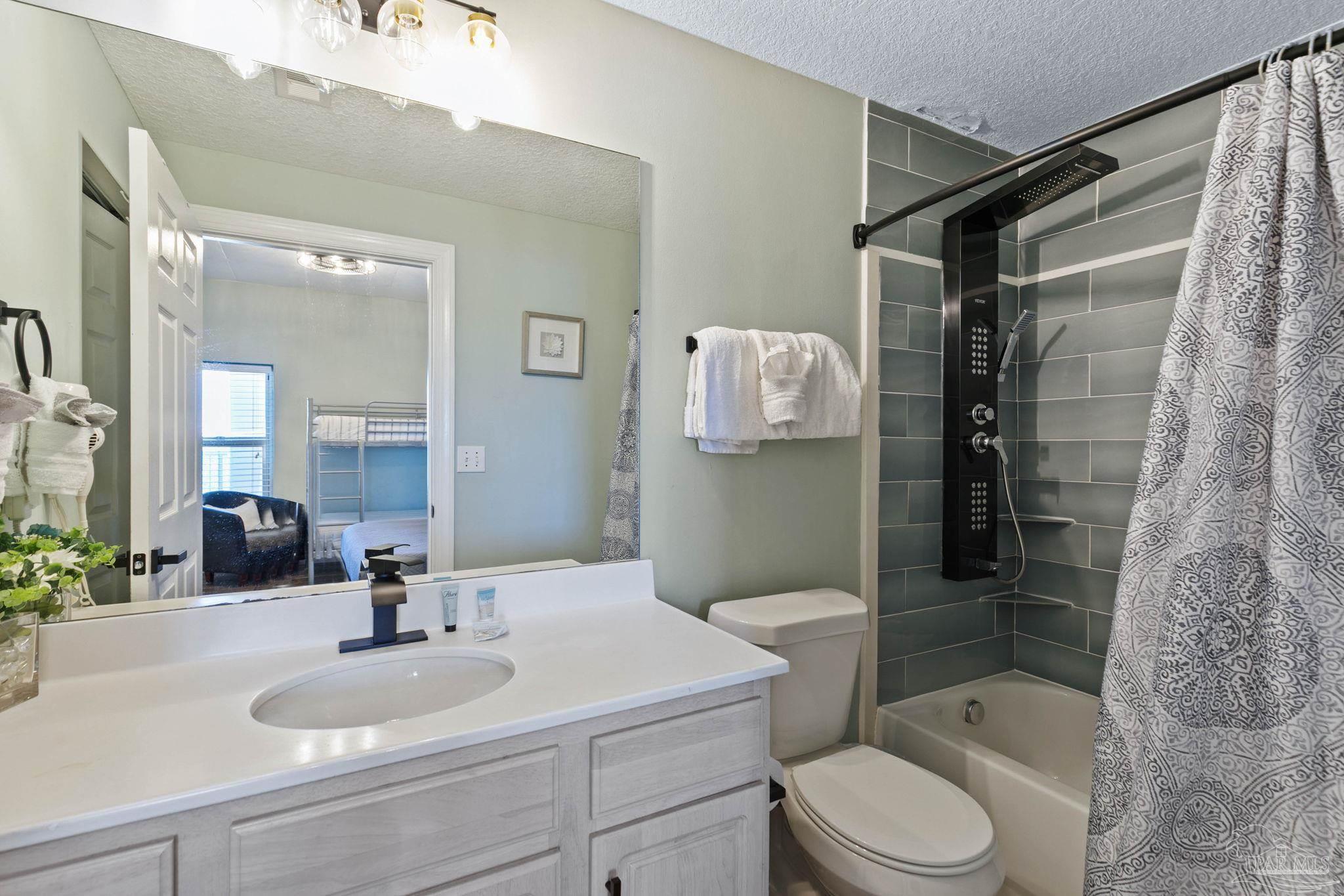 10611 Front Beach Road, Unit 1303 Panama City Beach, FL 32408 - Photo 45 of 71 a bathroom with a sink toilet and shower