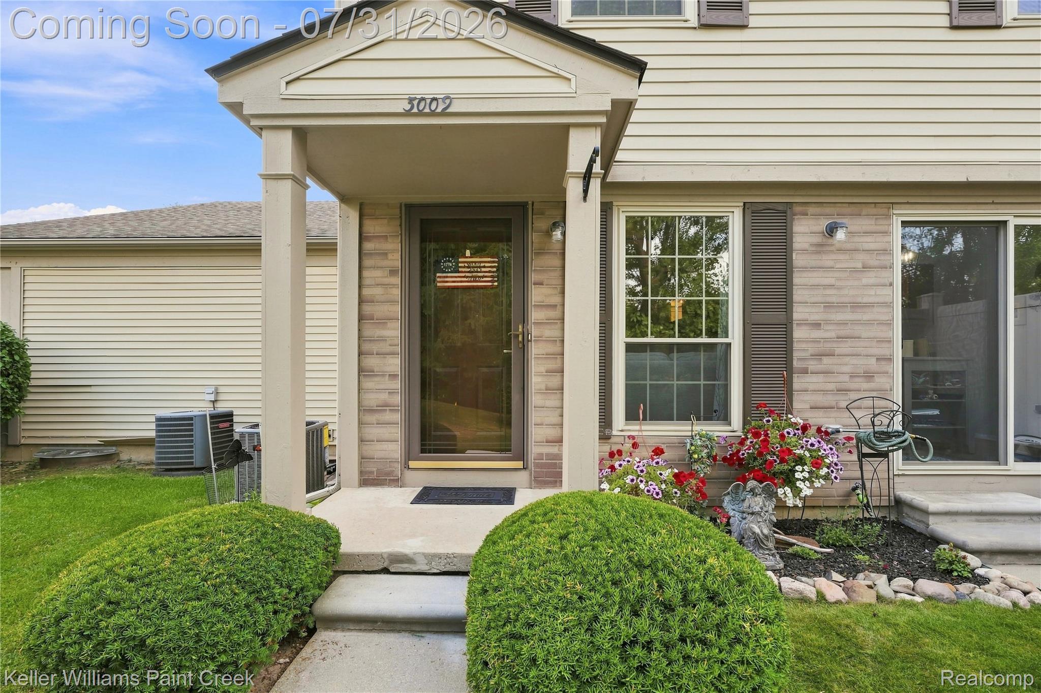 3009 High Pointe Ridge Road Lake Orion, MI 48359 - Photo 2 of 21 Front entry featuring a covered porch with column supports, a brick facade accent, horizontal siding, and a window with louvered shutters