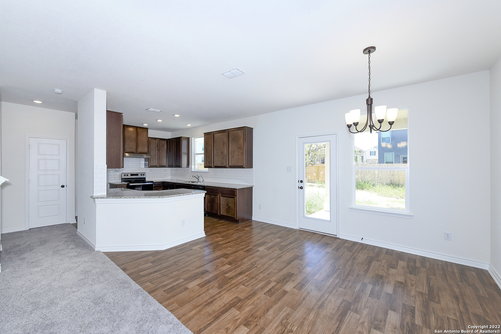 6511 Runaway Row Converse, TX 78109 - Photo 11 of 42 a large kitchen with kitchen island a sink dishwasher a refrigerator and a stove top oven
