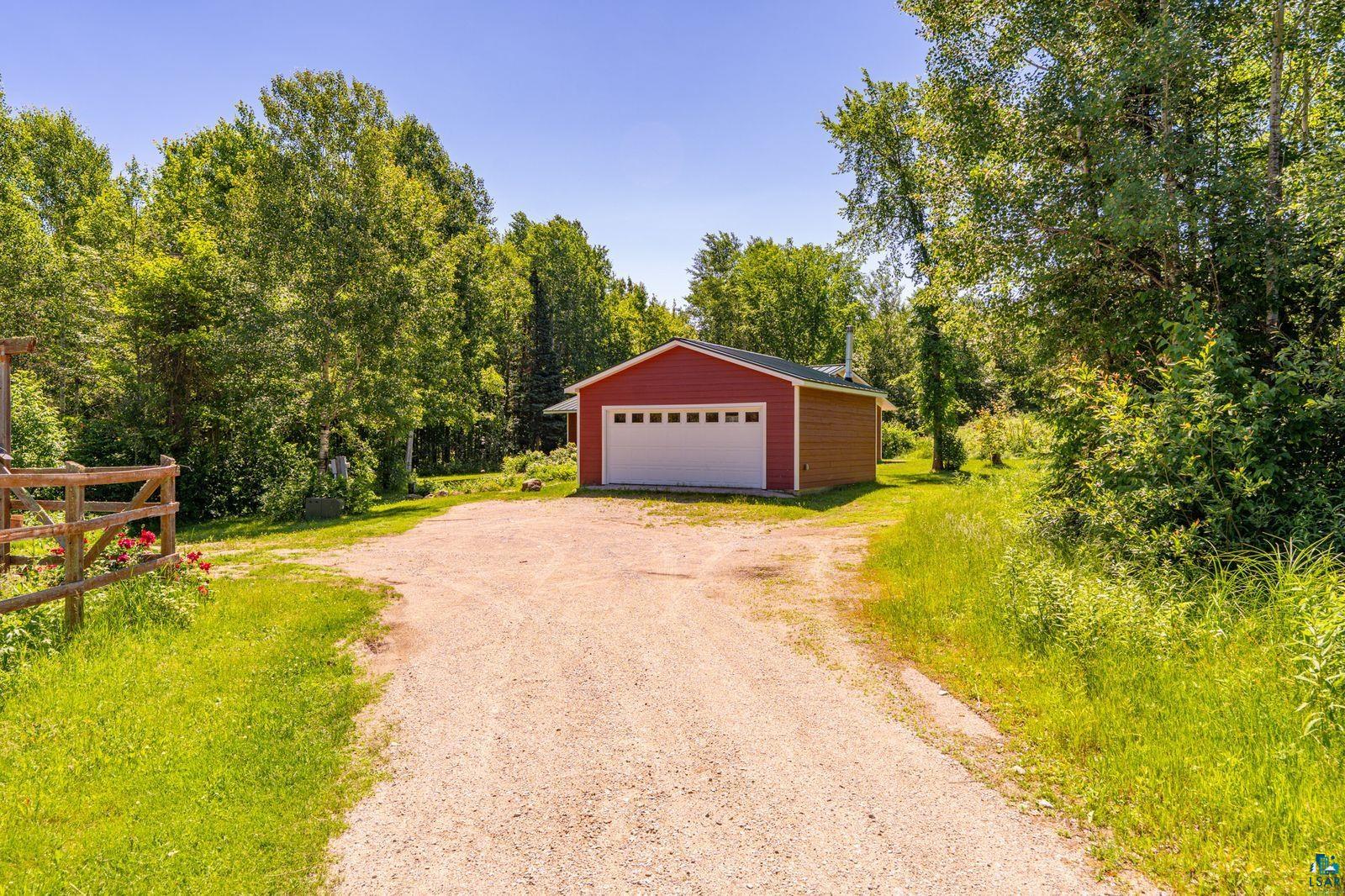 9734 Alango Road Angora, MN 55703 - Photo 31 of 41 Red detached garage with a white panel door and a gravel driveway