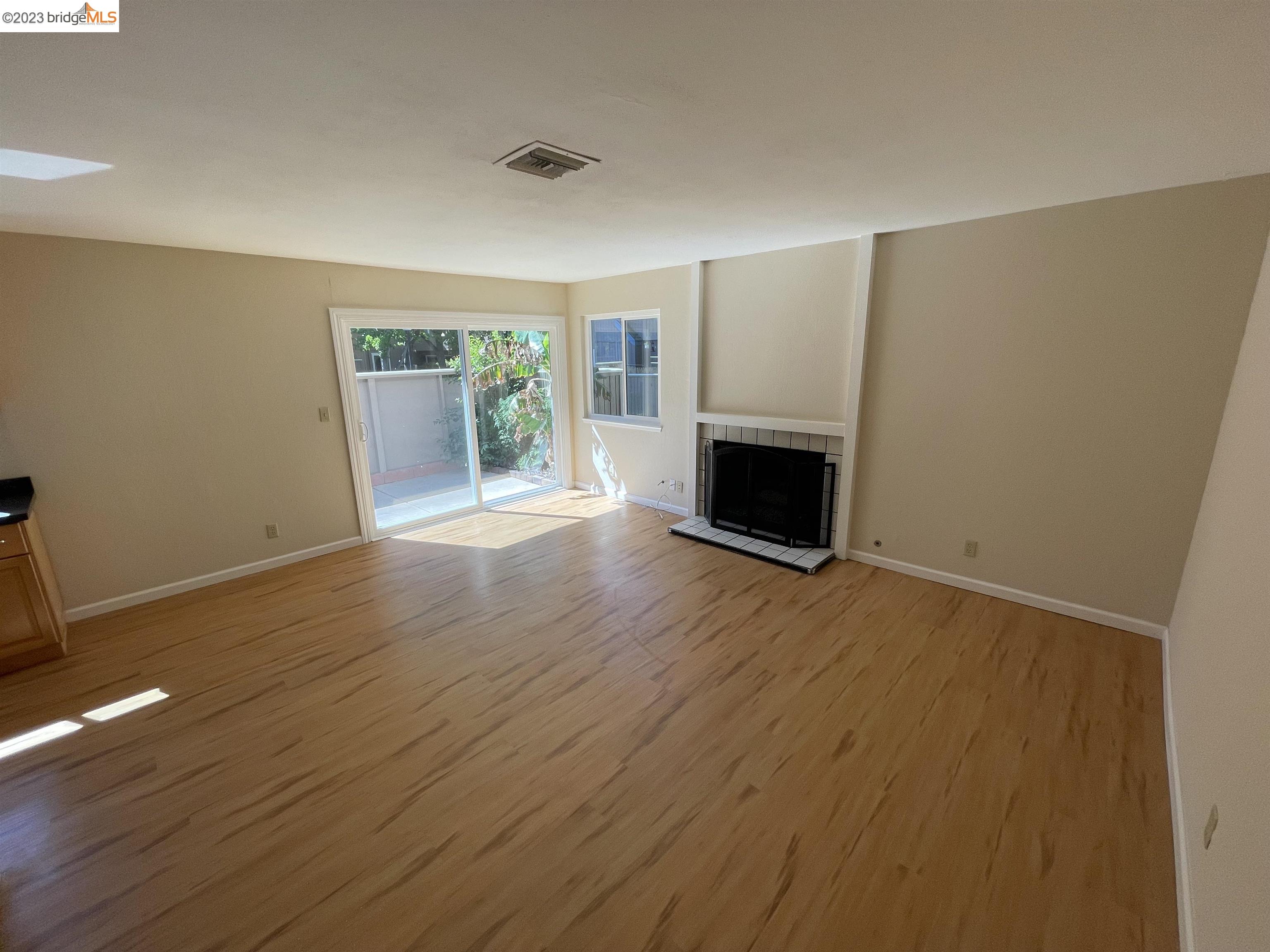 3901 Clayton Road, Unit 57 Concord, CA 94521 - Photo 5 of 40 an empty room with wooden floor fireplace and windows