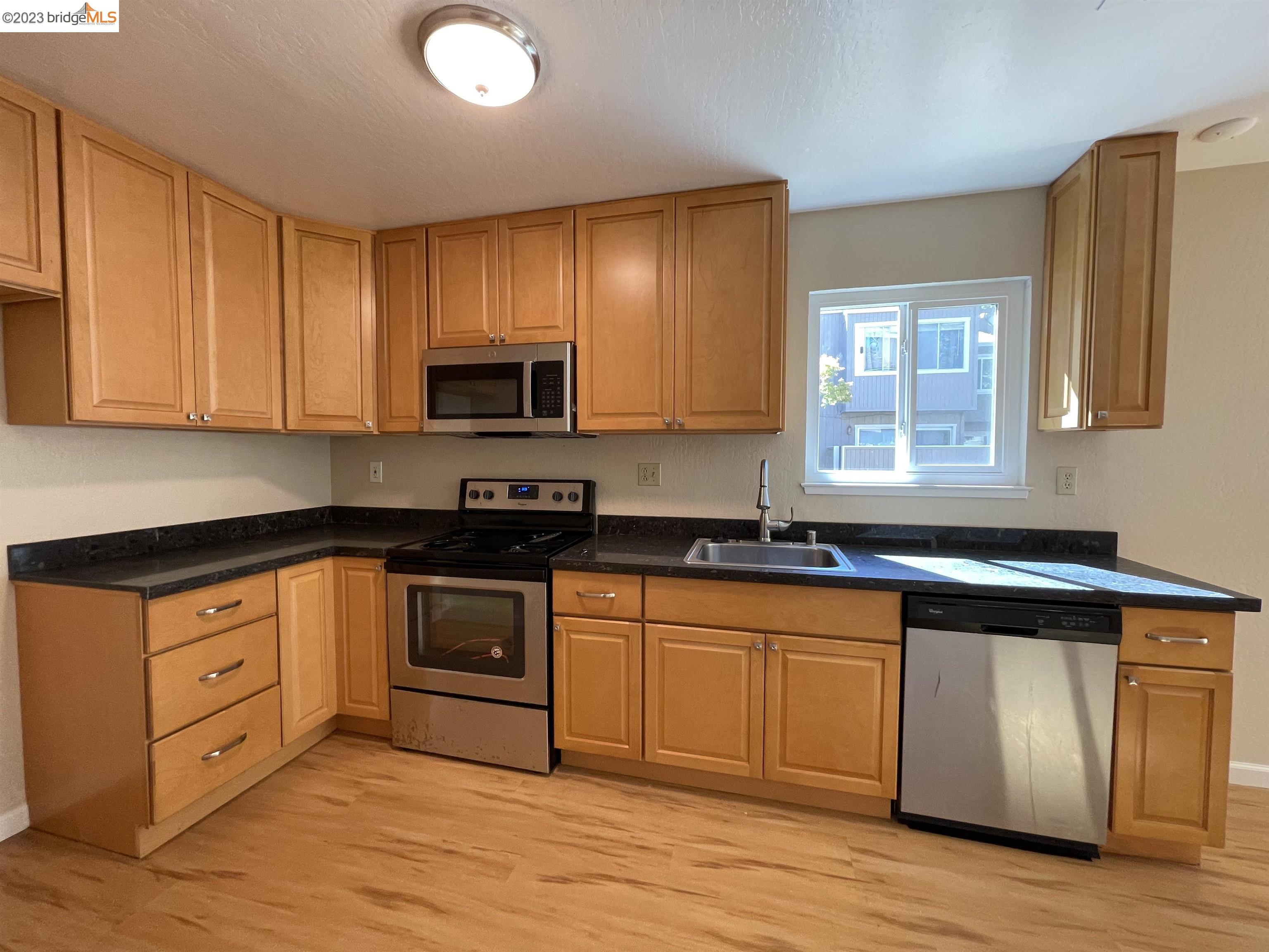 3901 Clayton Road, Unit 57 Concord, CA 94521 - Photo 7 of 40 a kitchen with stainless steel appliances granite countertop a stove a sink and a microwave