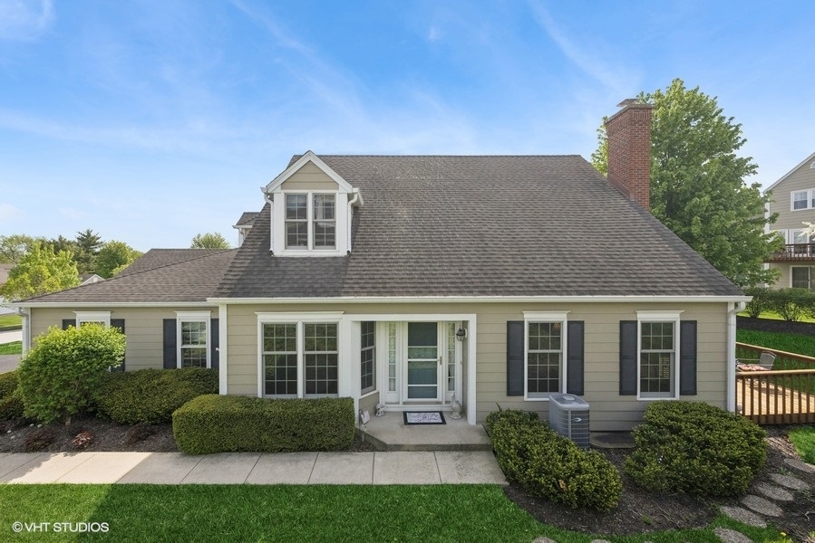 a front view of a house with a yard and plants