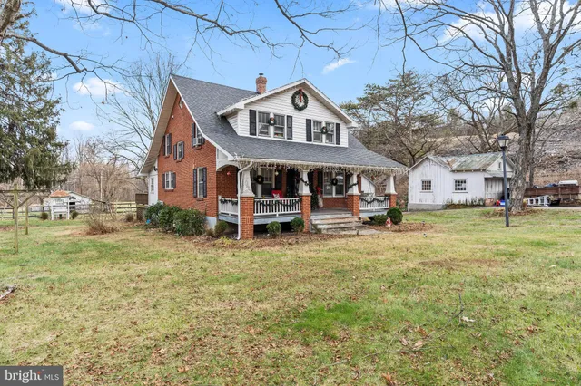 a front view of a house with garden and trees