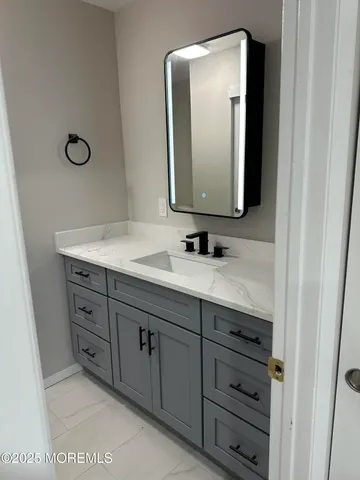 a bathroom with a sink vanity and mirror