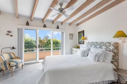 a bedroom with a bed and a view of fan