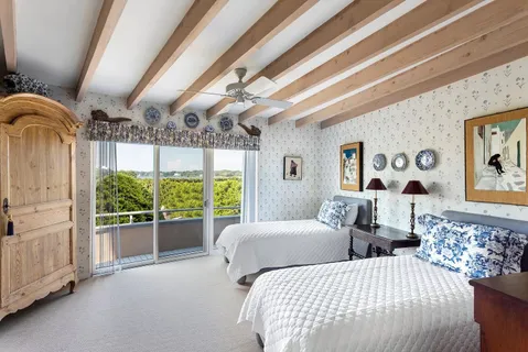 a bedroom with large windows and large bed