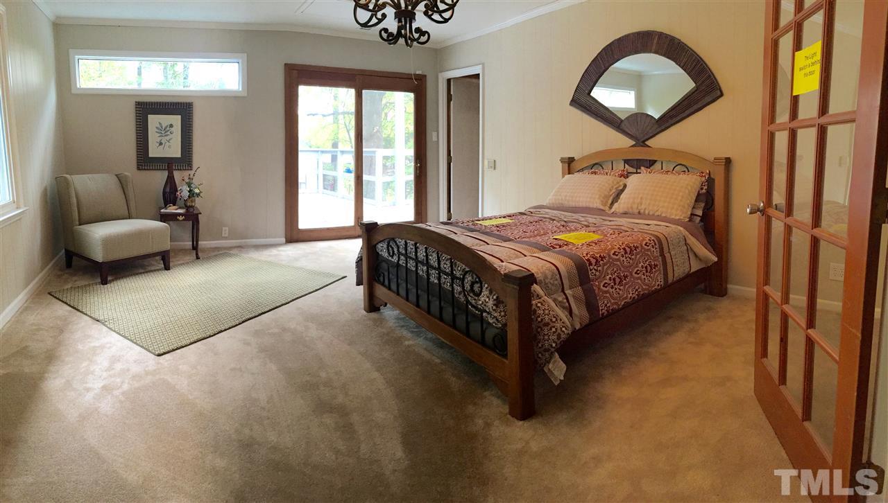 706 Chandler Road Durham, NC 27703 - Photo 14 of 24 a spacious bedroom with a bed and a large mirror