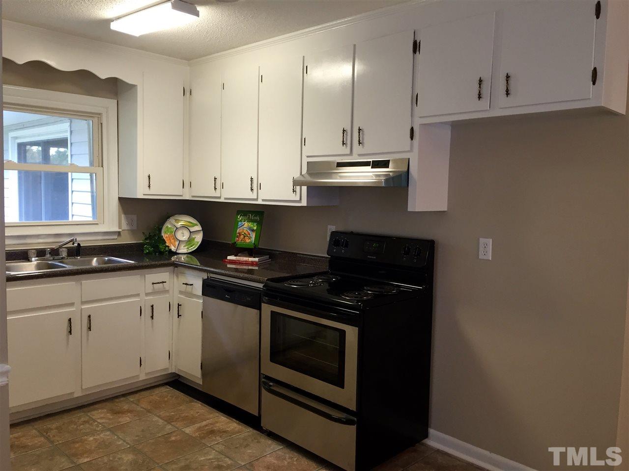706 Chandler Road Durham, NC 27703 - Photo 10 of 24 a kitchen with stainless steel appliances granite countertop a stove a sink and white cabinets