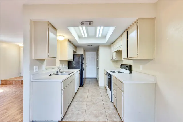a kitchen with a sink stove and cabinets