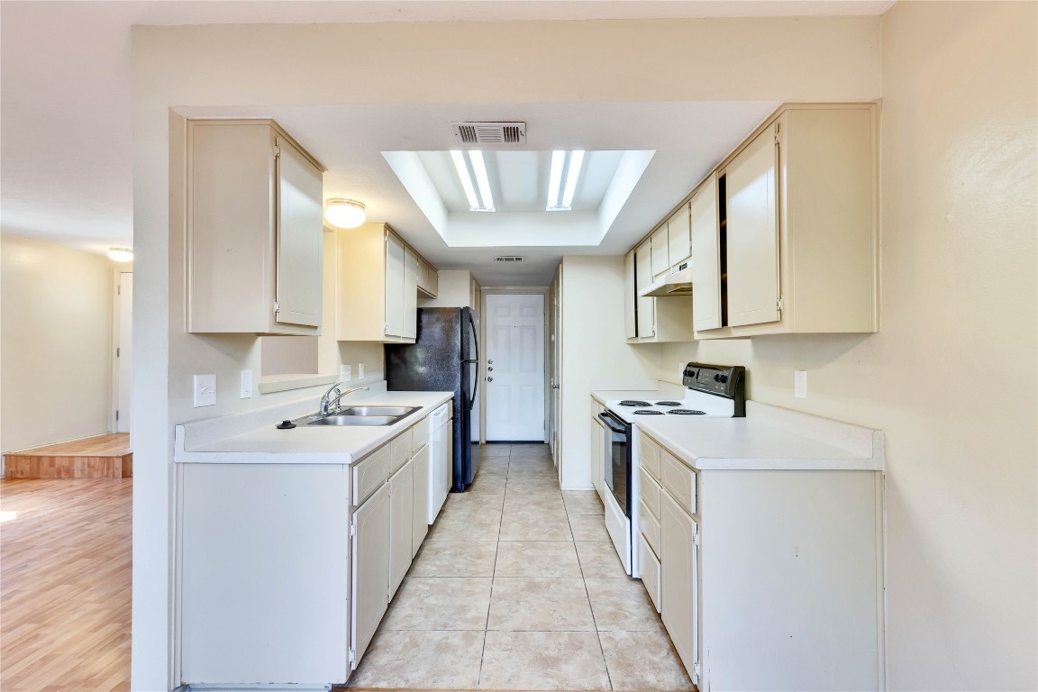 8806 Springmail Circle, Unit B Austin, TX 78729 - Photo 3 of 16 a kitchen with a sink stove and cabinets
