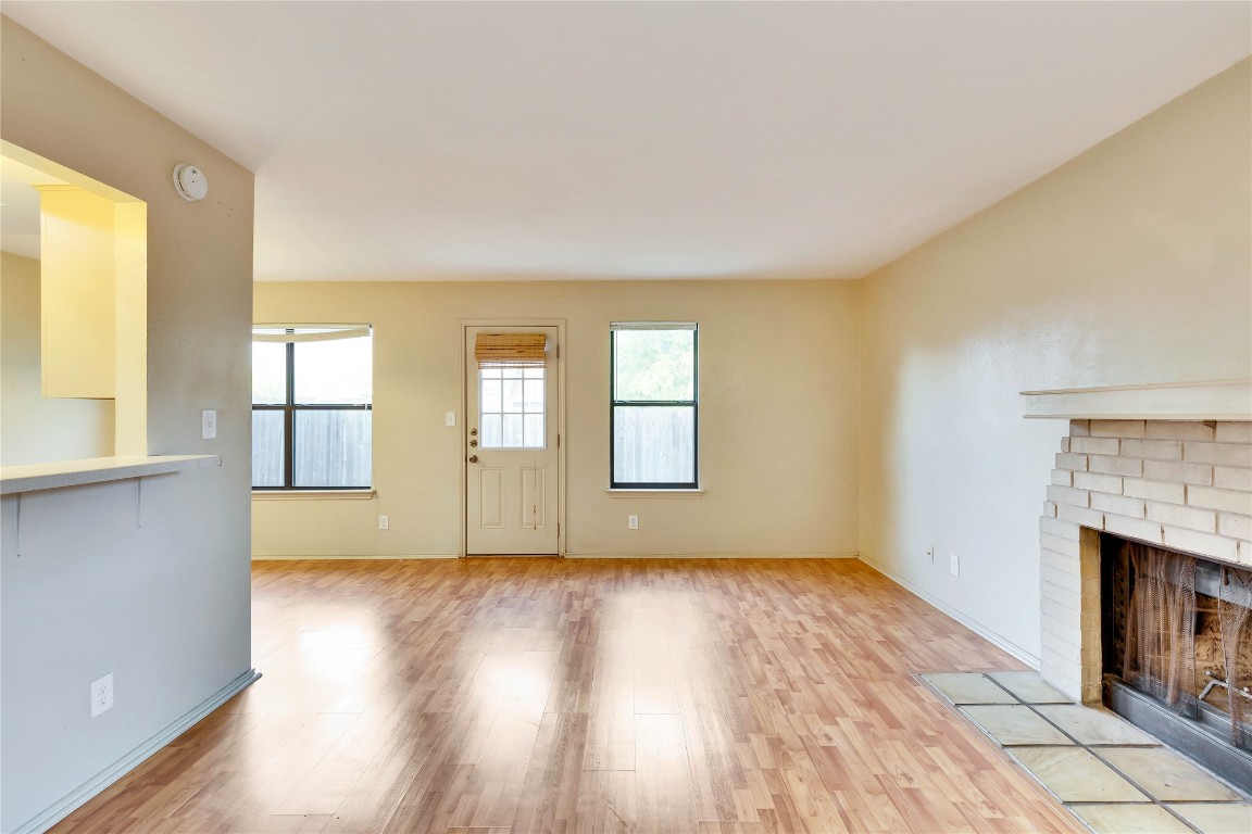 8806 Springmail Circle, Unit B Austin, TX 78729 - Photo 7 of 16 a view of an empty room with wooden floor and a window
