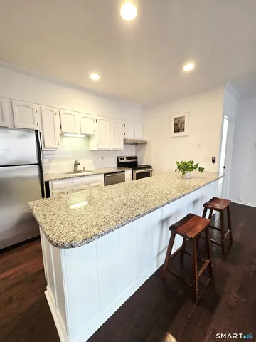 a kitchen with stainless steel appliances granite countertop sink stove and cabinets