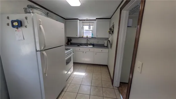 a kitchen with a refrigerator a stove top oven and cabinets