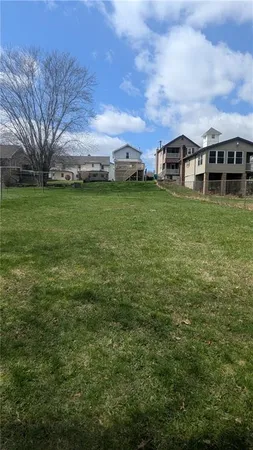 a front view of house with yard and trees in the background