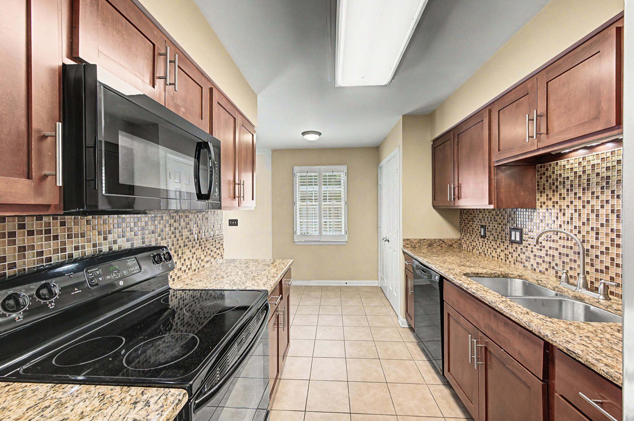 8300 Sawyer Brown Road, Unit A304 Nashville, TN 37221 - Photo 25 of 57 a kitchen with stainless steel appliances granite countertop a stove a sink and a microwave