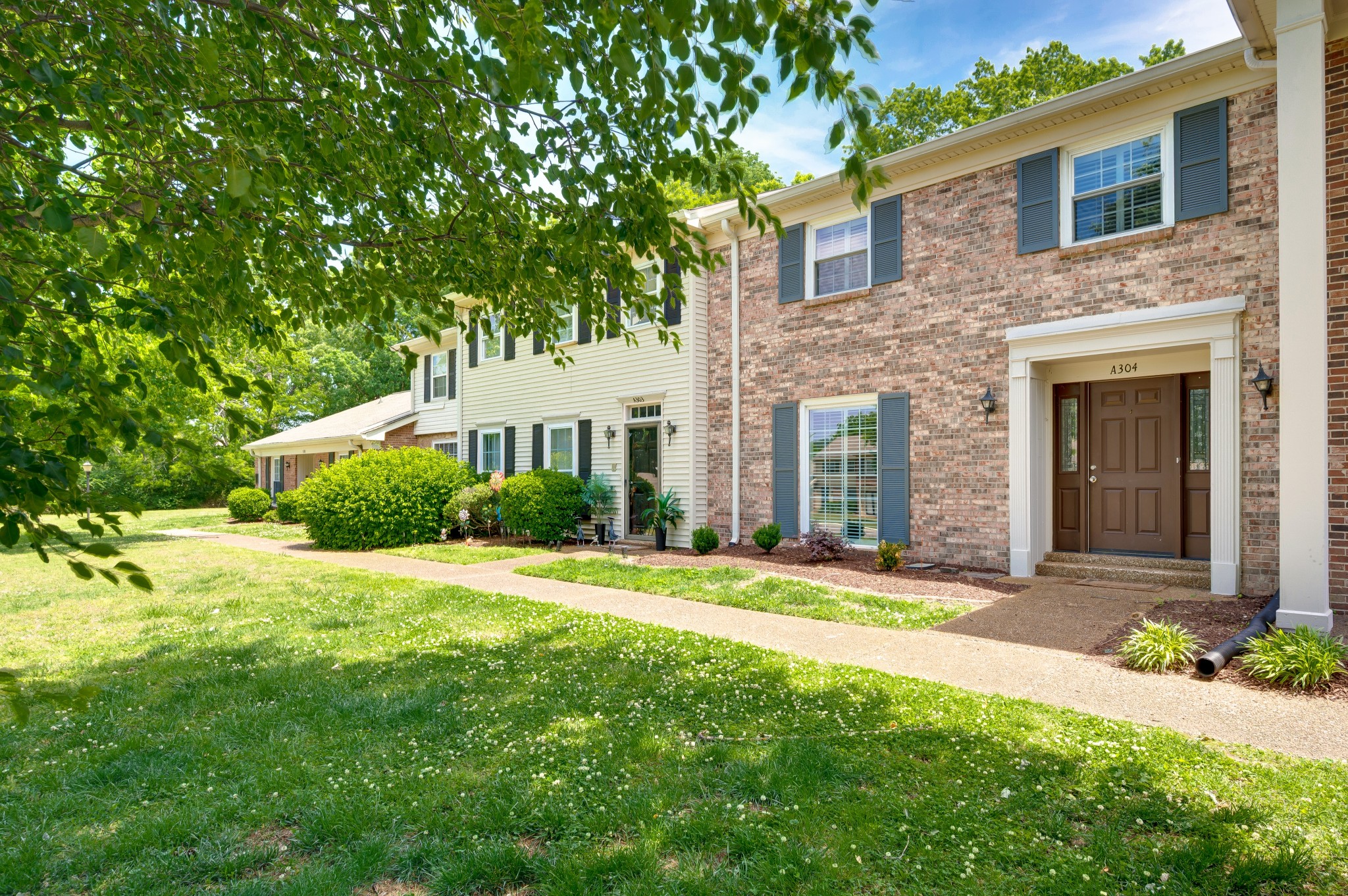 8300 Sawyer Brown Road, Unit A304 Nashville, TN 37221 - Photo 5 of 57 a front view of a house with a yard and garage