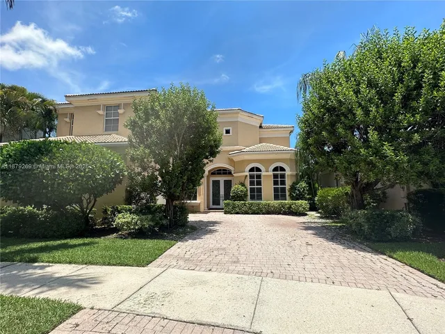 a front view of a house with a yard and trees