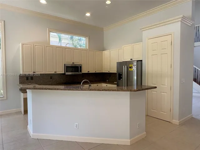 a kitchen with stainless steel appliances granite countertop a refrigerator and a stove