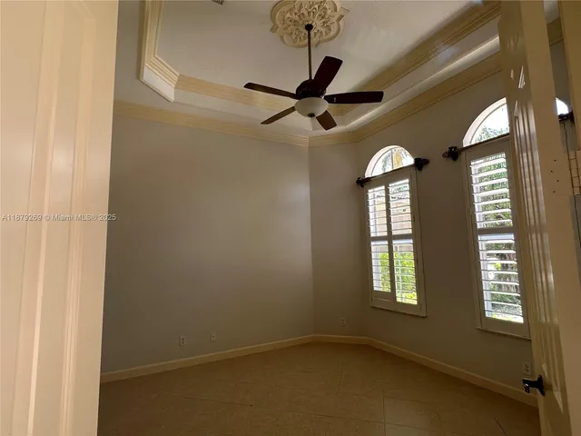 an empty room with windows and fan