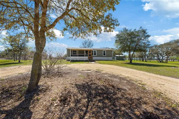 a view of a house with yard and trees