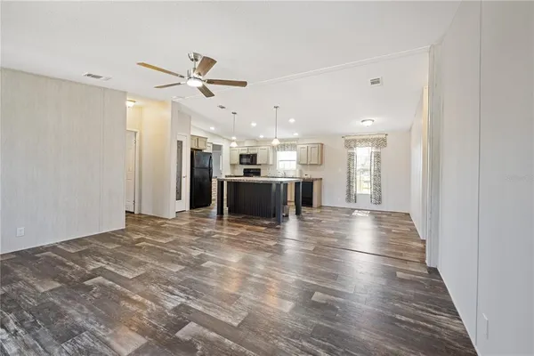 a kitchen with stainless steel appliances kitchen island granite countertop a stove a sink and a refrigerator