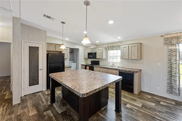 a kitchen with kitchen island a sink stainless steel appliances and counter space