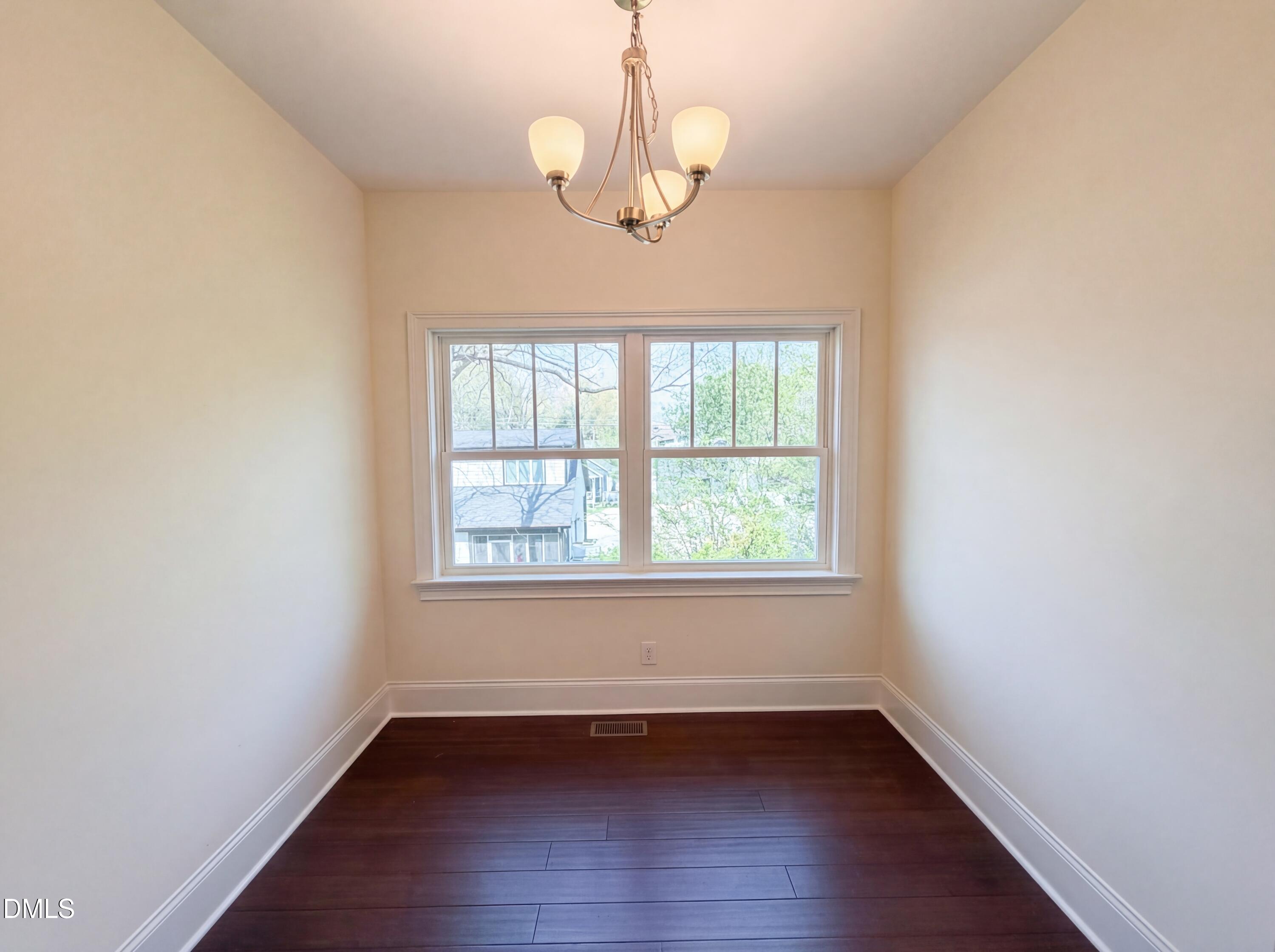 1007 Hazel Street Durham, NC 27701 - Photo 11 of 17 an empty room with wooden floor and windows
