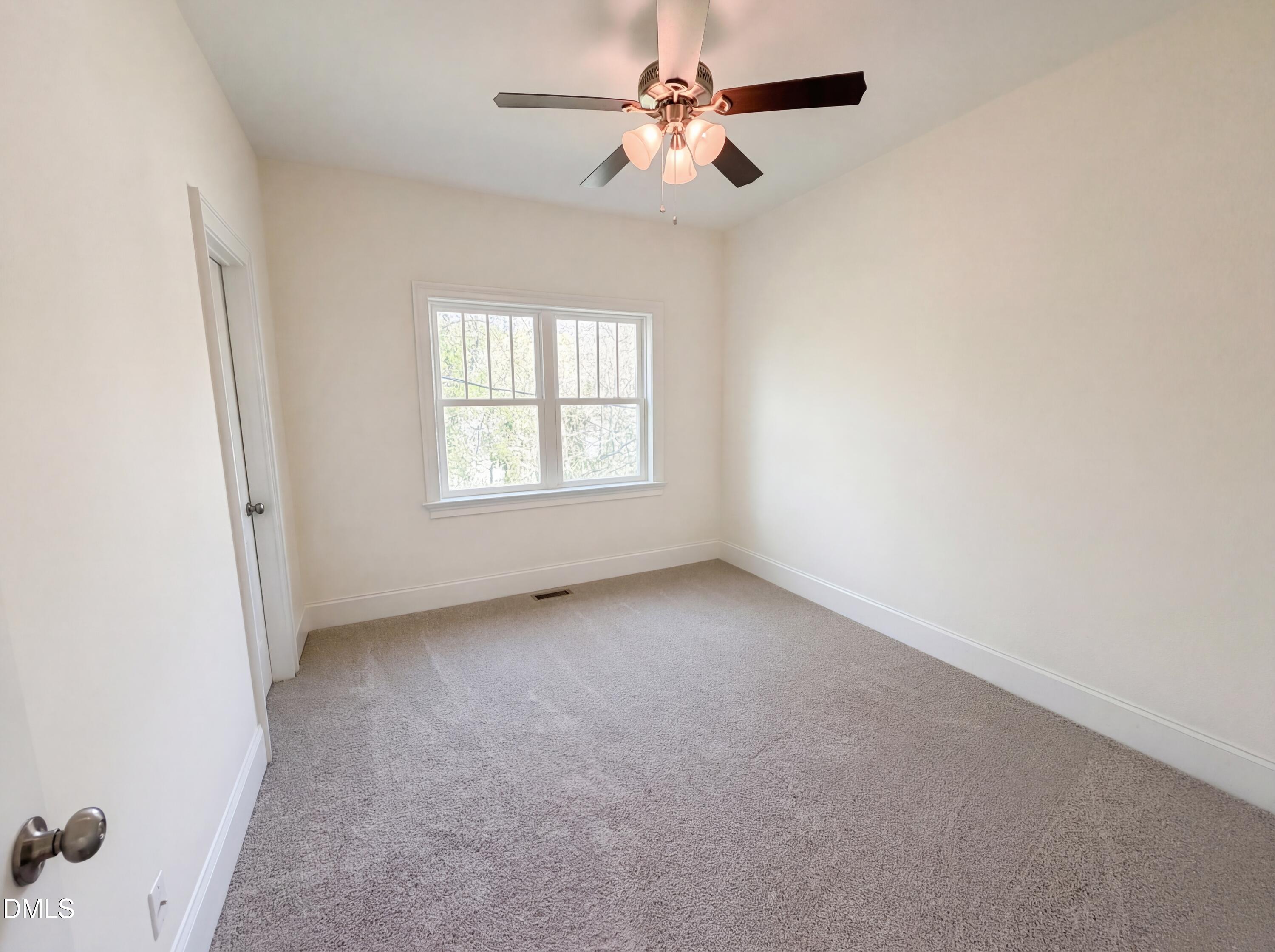 1007 Hazel Street Durham, NC 27701 - Photo 4 of 17 an empty room with windows and fan