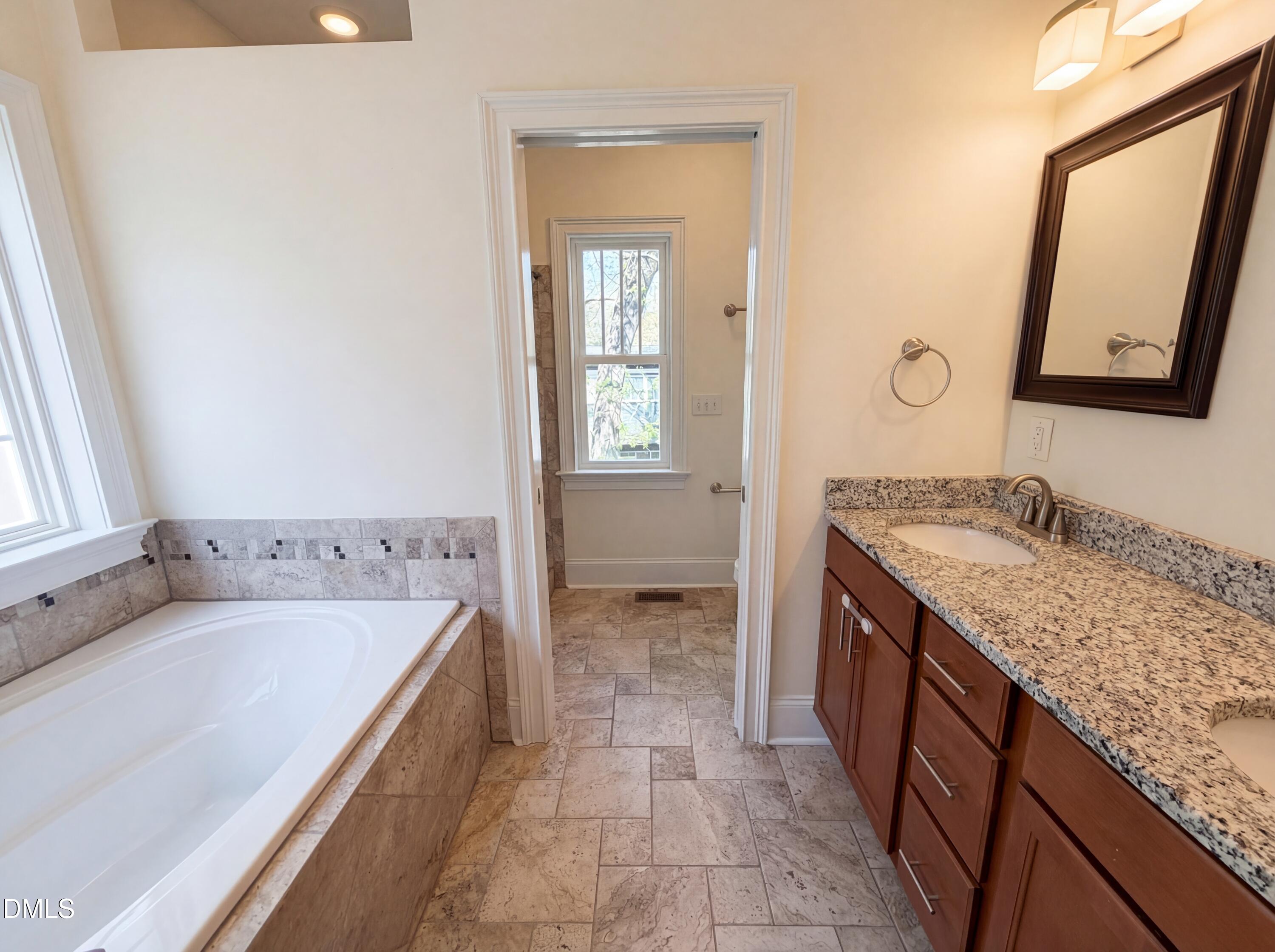 1007 Hazel Street Durham, NC 27701 - Photo 6 of 17 a bathroom with a granite countertop tub sink and mirror
