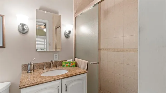 a bathroom with a granite countertop sink and a mirror