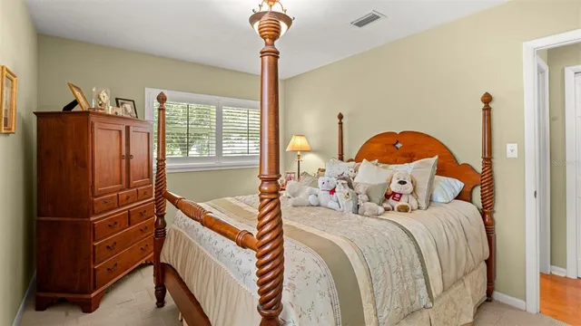 a bedroom with a bed next to a window