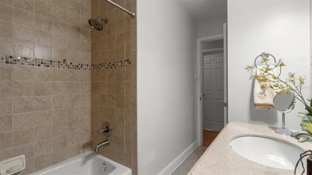 a bathroom with a granite countertop sink a mirror and shower