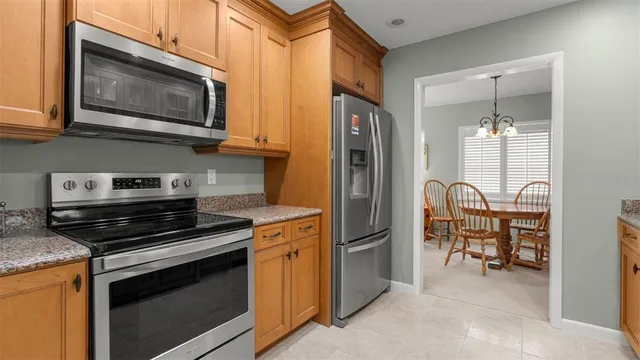 a kitchen with stainless steel appliances granite countertop a stove microwave and refrigerator
