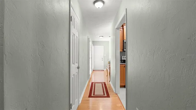 a view of a hallway with wooden floor and staircase