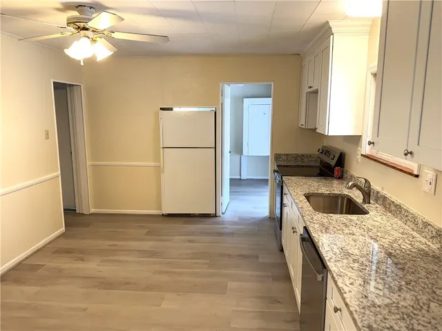a kitchen with a refrigerator sink and cabinets