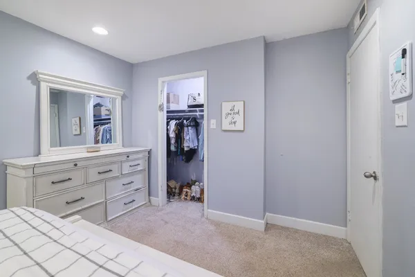 a room with a bed and a dresser in it