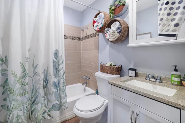 a bathroom with a granite countertop toilet sink and mirror