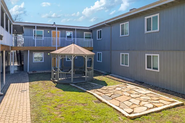 a backyard of a house with barbeque oven table and chairs