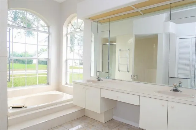 a bathroom with a large tub sink and double vanity