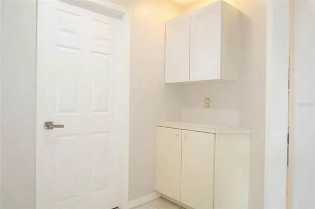 an empty room with windows and cabinet