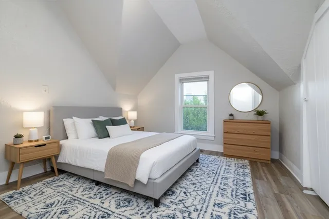 a bedroom with a bed and wooden floor