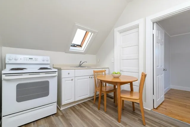 a view of a kitchen area with furniture and wooden floor