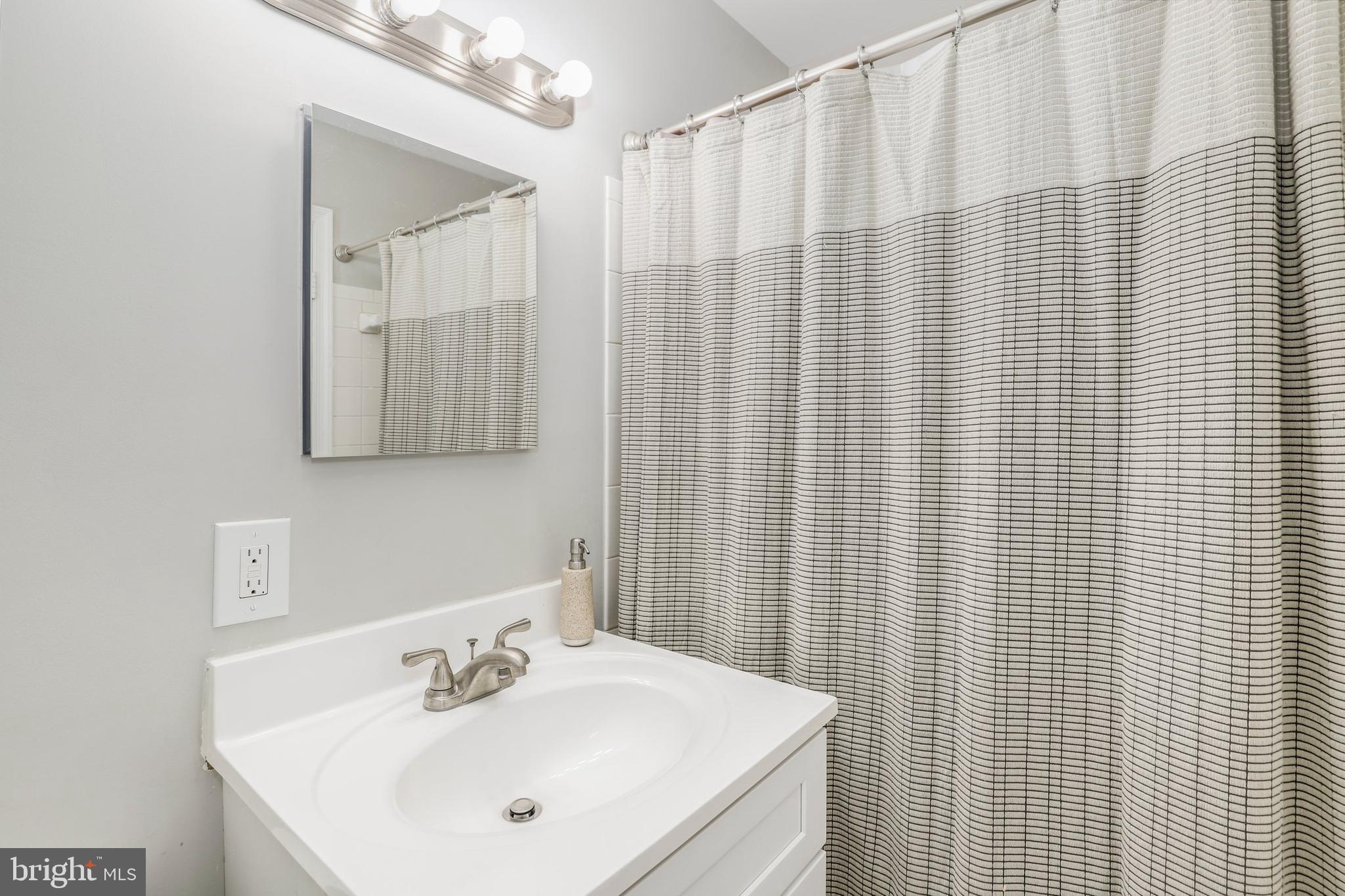 8461 Thames Street Springfield, VA 22151 - Photo 41 of 57 a bathroom with a shower curtain and a sink