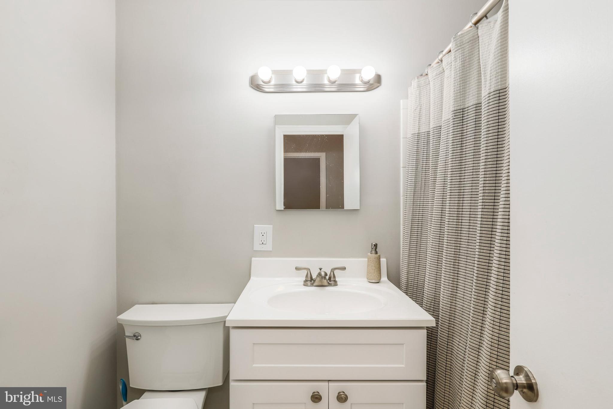 8461 Thames Street Springfield, VA 22151 - Photo 42 of 57 a bathroom with a sink a toilet and mirror